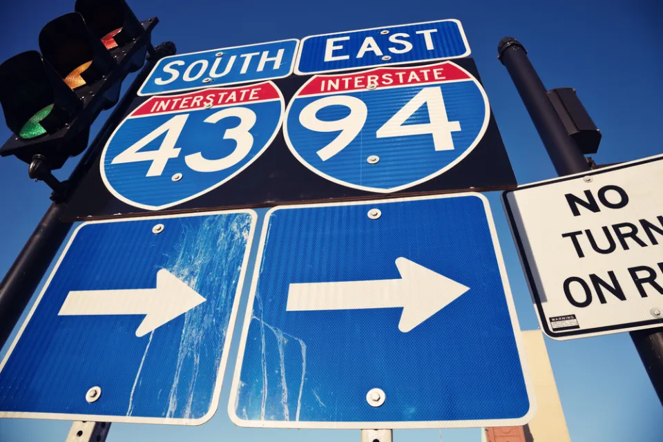 Closeup of blue I-94 and I-43 signs with arrows